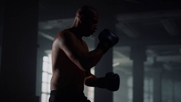 男性ボクサーパンチバッグキック。スポーツバッグの上でキックを練習する男 - 写真・画像