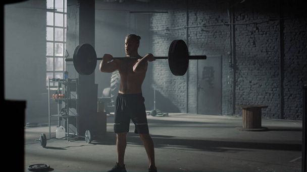 Powerlifter beim Gewichtheben im Fitnessstudio. Mann führt Kniebeuge vor  - Foto, Bild