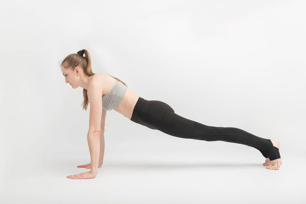 Übungsplatte. Frau macht Fitnessübungen. Volle Planke von Sport Woman. Mädchen Yoga auf weißem Hintergrund - Foto, Bild