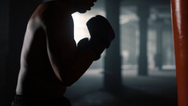 Homme se déplaçant activement pendant l'entraînement. Boxer boxe avec sac de boxe - Photo, image