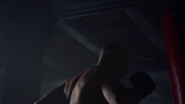 Férfi boxzsák a fitness klubban. Férfi harcos kickbox sporttáska - Fotó, kép