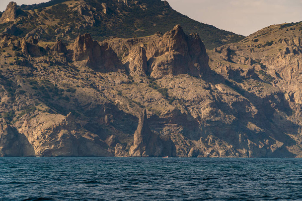 Die Republik Krim. 21. Juli 2021. Iwan der Räuberfelsen am Fuße des Kara-Dag-Berges in der Nähe der Stadt Koktebel. - Foto, Bild