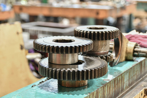 Δίσκοι και εργαλεία διαχωρισμού για την αλλαγή της ταχύτητας μιας τέμνουσας μηχανής μετάλλου που επισκευάζεται σε εργαστήριο. - Φωτογραφία, εικόνα