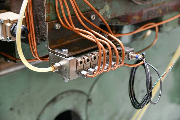 Distributeur de pression d'une station d'huile haute pression d'une machine de découpe de métaux en cours de réparation dans un atelier. - Photo, image