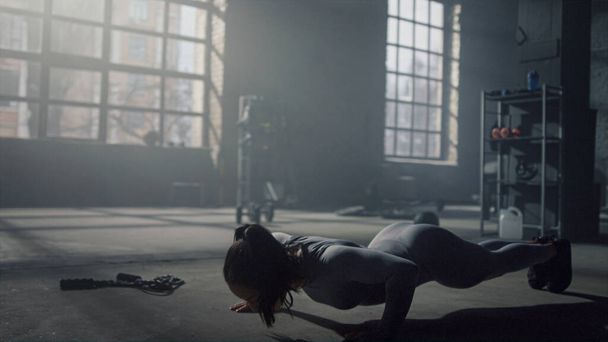 Vrouw doet push-ups op de vloer in de sportschool. Fitness meisje training buikspieren - Foto, afbeelding