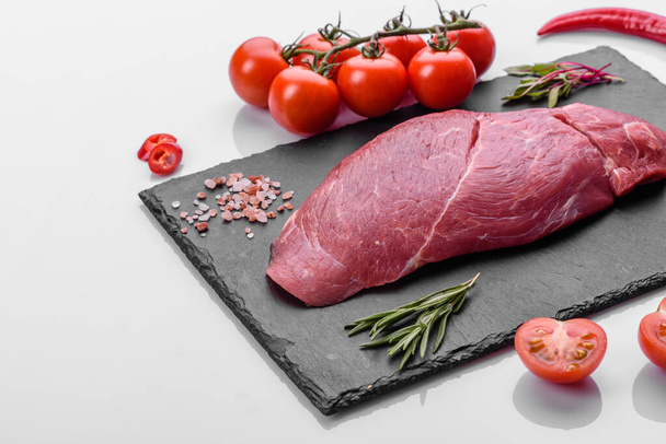 Raw fresh Chuck roll steak with herbs and salt on a cutting Board. Gray background - Photo, Image
