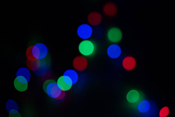 Defocused πολύχρωμα φώτα bokeh σε μαύρο φόντο, μια αφηρημένη φυσικά θολή φόντο - Φωτογραφία, εικόνα