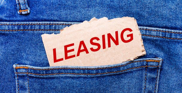 In the back pocket of the jeans there is a brown piece of paper with the text LEASING - Foto, Imagem