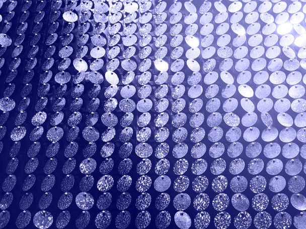 Niski kąt teksturowanego tła okrągłych cekinów w girlandach lśniących jasno z kolorem 2022 roku bardzo peri - Zdjęcie, obraz