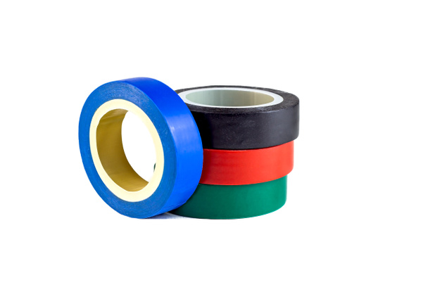 Carretes de cinta eléctrica aislante adhesivo rojo, verde y azul apilados sobre fondo blanco. - Foto, Imagen