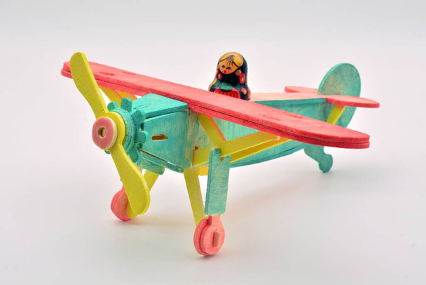 Russische matrioshka pop gemonteerd op een speelgoedvliegtuig, beschilderd in kleuren - Foto, afbeelding