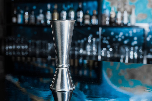 Джиггер - это металлический брусок или чашка для контроля и количества ингредиентов, добавляемых в коктейль.. - Фото, изображение