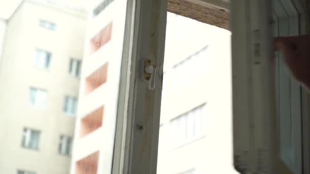 mies avaa ikkunan asunnon ikkunassa - Materiaali, video