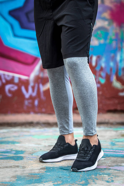 a man in gray sports leggings and sneakers. - Foto, Imagen
