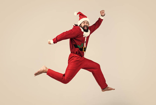 Full body photo of amazed jumping man excited by x-mas prices hurry shopping wear santa claus costume, happy new year - Фото, изображение