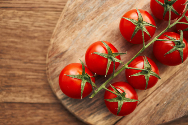 cherry tomatoes on a branch on a wooden board kitchen ingredient fresh food - Foto, afbeelding