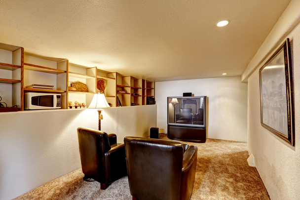 υπόγειο δωμάτιο με τηλεόραση και δύο καρέκλες δέρματος - Φωτογραφία, εικόνα