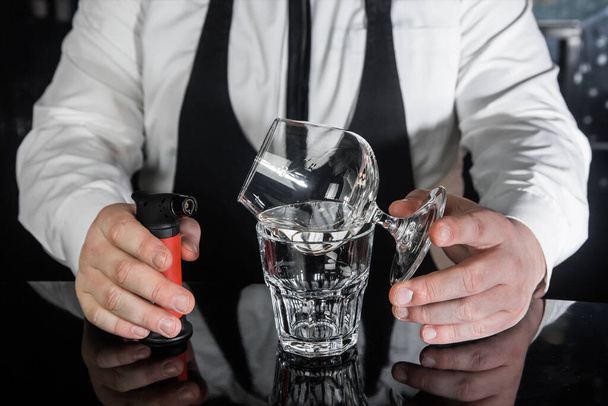 The process of preparing an alcoholic hot cocktail with Italian liqueur of a drink in sambuca glass. - Foto, Bild