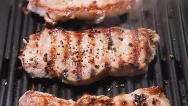 A Top View on Meat egy elektromos grillen van megsütve közelről. 4K felbontású videó. Sertéshús közelről sült és füstölt a grillen. - Felvétel, videó