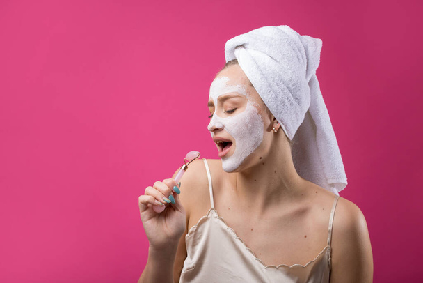 Girl with a cosmetic mask on her face in a white towel. - Photo, Image