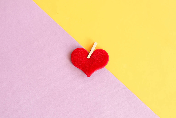 Magányos szív: vörös szív lila-sárga háttérrel, felülnézet, szöveges hely. - Fotó, kép