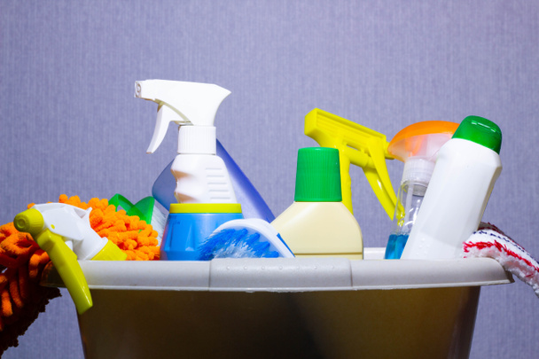 Mand met wasmiddelen op tafel. Onschadelijk vaatwasmiddel. Wasmiddel voor vloeren. Chemicaliën voor huishoudelijk gebruik. Chemische stoffen. In water oplosbare stoffen de chemische industrie. - Foto, afbeelding