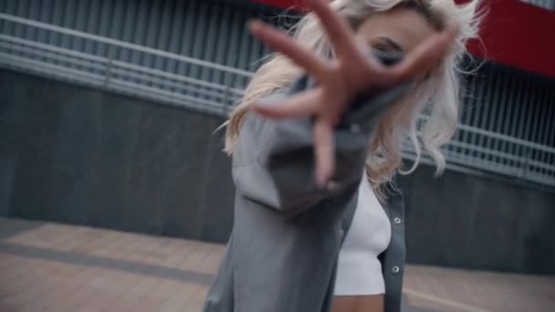 Modern şehir sokaklarında güzel bir kadın model el hareketi yapıyor..  - Video, Çekim