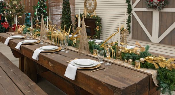 素朴なクリスマスはテーブルを提供しました。テーブルはリビングルームでクリスマスディナーのために提供しました。お祝いの装飾とクリスマステーブルの設定。誰もいない - 写真・画像