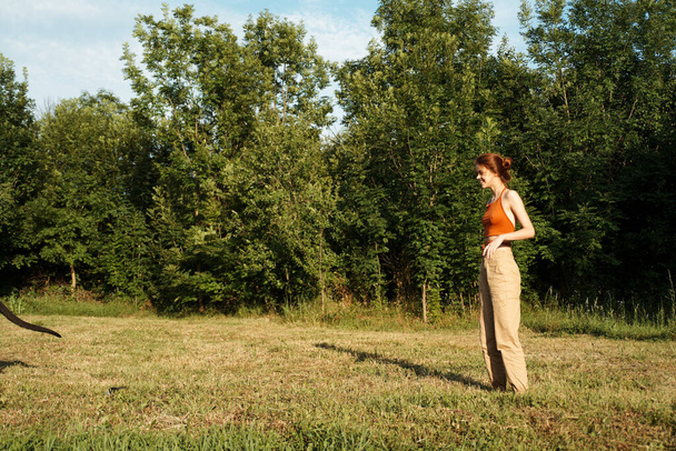 woman playing with a big black dog outdoors in the field fun friendship - Фото, зображення