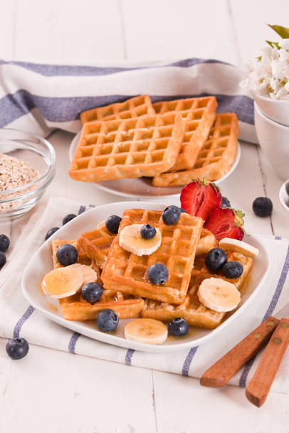 Waffles with blueberries, bananas and honey. - Foto, afbeelding