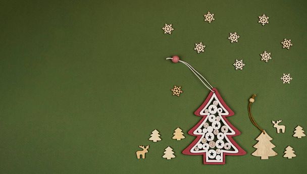 Weihnachtsbaumspielzeug aus Holz auf grünem Hintergrund. Konzept von Weihnachten. - Foto, Bild
