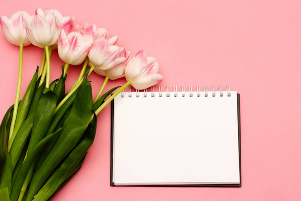 Un beau bouquet de délicates tulipes roses se trouve sur un fond rose avec une place pour votre texte sur un fond blanc - Photo, image