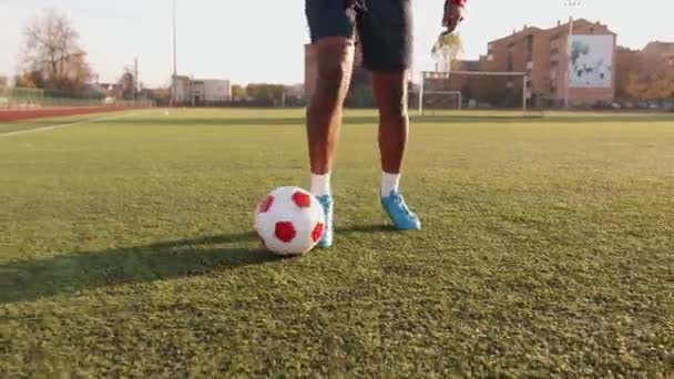 Detailní záběr na nohy černého fotbalisty, který trénuje držení míče při tréninku. Fotbalové kapání - Záběry, video