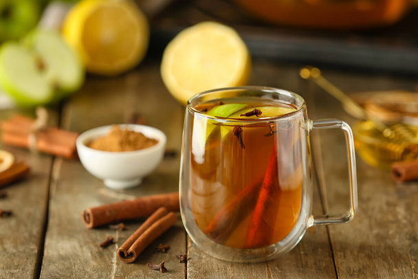 Glass cup of tasty fruit tea with cinnamon on table - Photo, Image