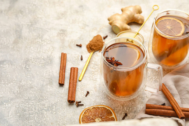 Glass cups of tasty fruit tea with cinnamon on light background - Photo, Image