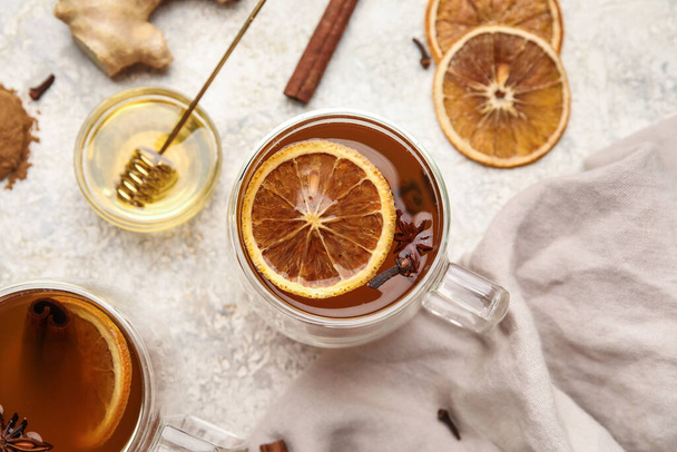 Glass cups of tasty fruit tea with cinnamon on light background - Foto, afbeelding