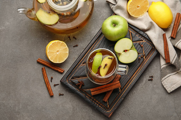 Üveg csésze finom gyümölcs tea fahéjjal szürke háttér - Fotó, kép