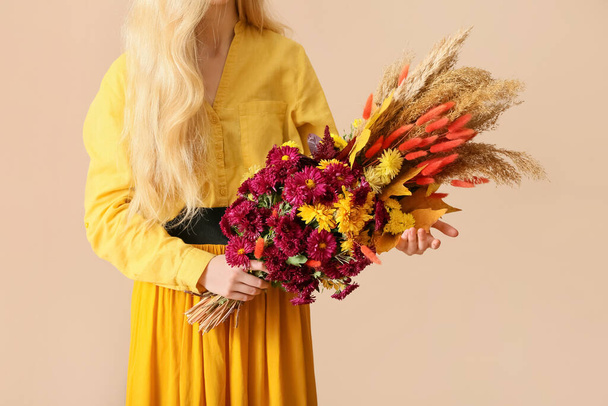 Женщина с красивым осенним букетом на цветном фоне - Фото, изображение