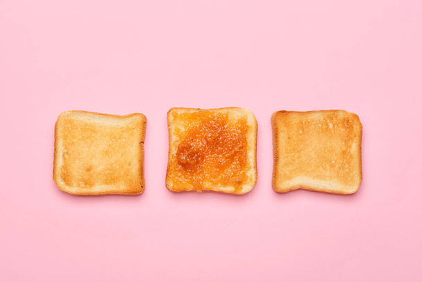 Lekkere peer jam en brood op roze achtergrond - Foto, afbeelding