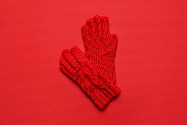 Paar gestrickte Handschuhe auf rotem Hintergrund - Foto, Bild