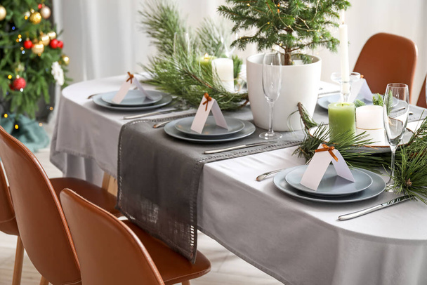 Mesa de comedor con hermoso escenario para la celebración de Navidad con tarjetas en blanco en el interior - Foto, imagen