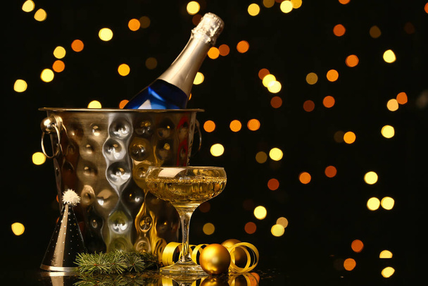 Bottle and glass of champagne with Christmas decor on table against blurred background - Photo, Image