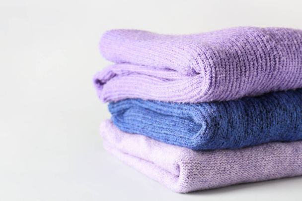 Montón de suéteres modernos suaves sobre fondo claro - Foto, imagen