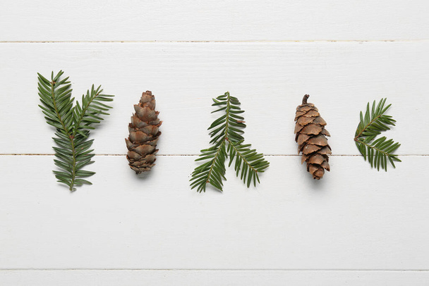 Fir branches and cones on light wooden background - Foto, immagini
