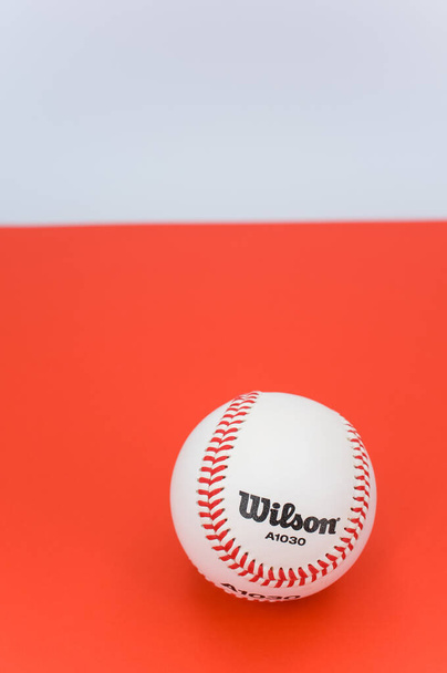 INVERIGO, ITALY - Dec 08, 2021: isolated baseball ball on a red background with text space - Foto, imagen