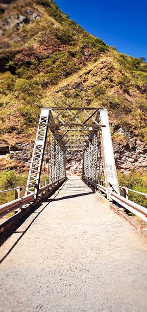 A beautiful shot of a bridge leading to the mountain on a sunny day - 写真・画像