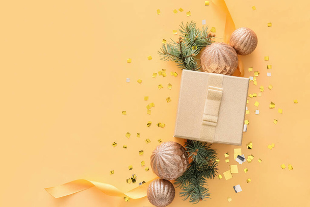 Composition with Christmas gift box, balls and fir branches on beige background - Foto, Bild