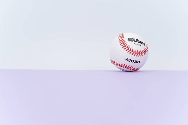 INVERIGO, ITALY - Dec 08, 2021: isolated baseball ball on a lilac background with text space - Zdjęcie, obraz