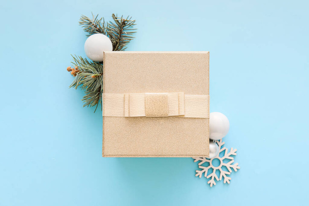 Composition avec coffret cadeau de Noël, boules et branche de sapin sur fond bleu - Photo, image