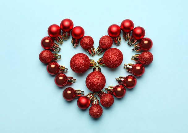 Heart made of Christmas balls on blue background - Photo, Image
